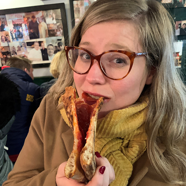 Charlotte Fazekas in New York with a big slice of pizza