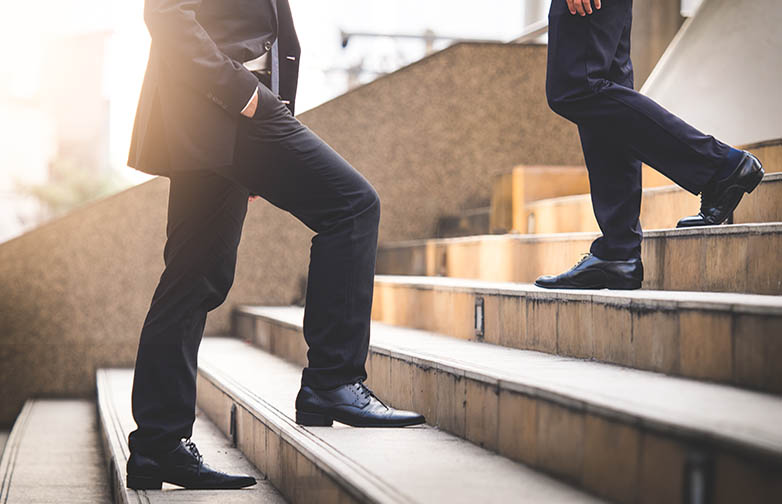 Close up legs of businessman walking stepping up stair in modern city, business growth, go up, success, grow up business concept