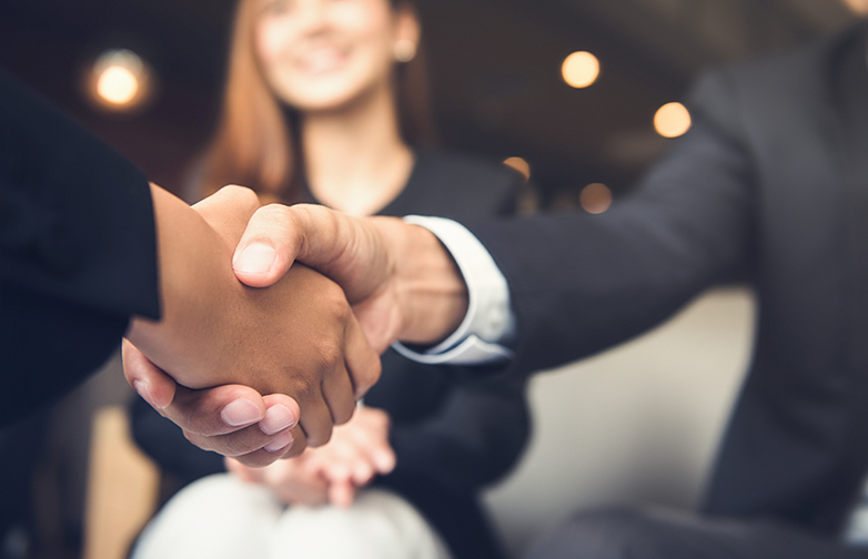 Businessmen shaking hands after meeting in a cafe