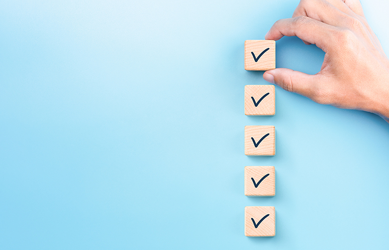 Checklist concept, Check mark on wooden blocks, blue background with copy space